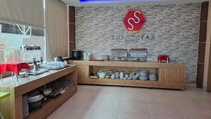 Buffetopstelling met een achtergrond van een stenen muur, een stopbord en een bord met de tekst 'SUPERSTAR HOTEL'.