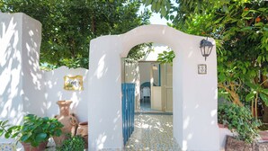 Un arco blanco que conduce a una habitación con suelo de baldosas y una puerta azul.