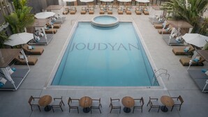 A pool area with lounge chairs, umbrellas, and tables. - Joudyan Jeddah Red Sea Mall (Jeddah)