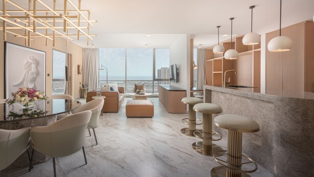 A modern living room with a glass coffee table, beige sofas, and a view of the city. - Joudyan Jeddah Red Sea Mall (Jeddah)