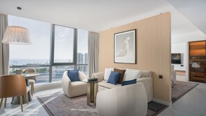 A modern living room with a sofa, armchairs, a coffee table, and a large window offering a city view. - Joudyan Jeddah Red Sea Mall (Jeddah)