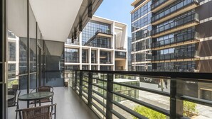 Un bâtiment moderne doté de nombreux balcons, de grandes fenêtres et d’une façade en verre.
