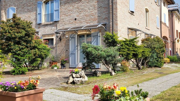 A two-story brick house with a garden in front. - Studio Apartment B4 (Modena)