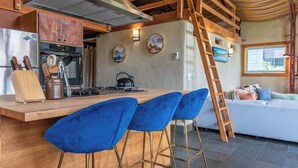 A kitchen with a wooden island, bar stools, and a stove. - Teton Homestead: Cozy Cabin in Downtown Victor (Victor)