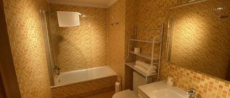 A bathroom with a bathtub, toilet, and sink.