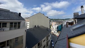 Un quartier résidentiel composé de plusieurs immeubles, dont un bâtiment blanc imposant doté d’un toit plat et un bâtiment gris avec un toit en pente.