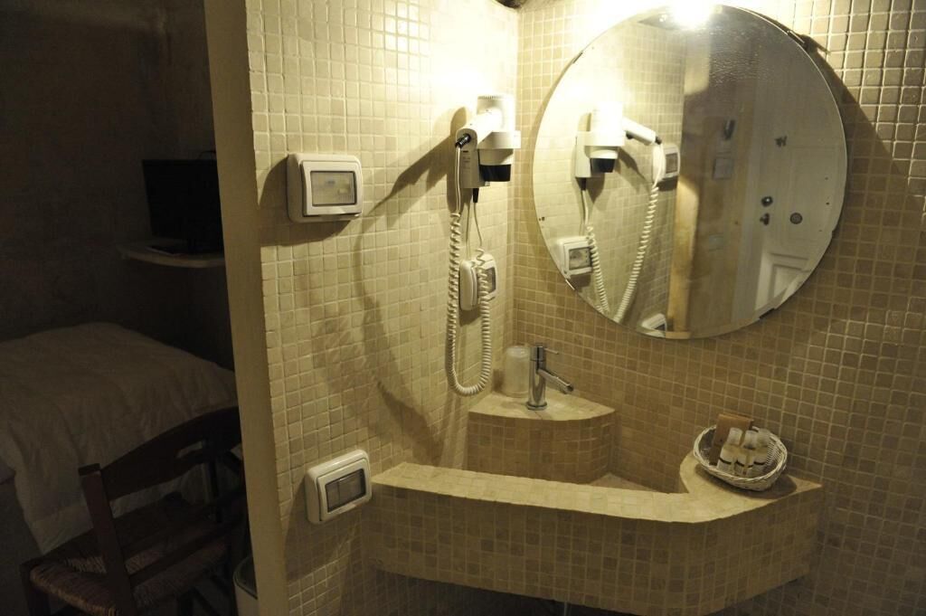 Un baño con lavamanos, espejo y teléfono.
