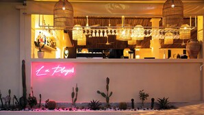 A bar area with hanging lights, a neon sign, and various plants. - Casa Solana Patong (Patong)