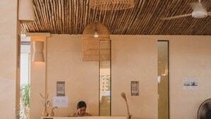 A reception area with a bamboo ceiling, wicker chairs, and a reception desk. - Casa Solana Patong (Patong)