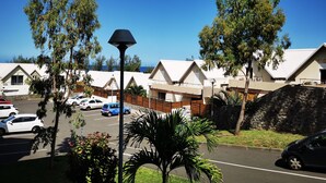 A row of white, pitched-roofed cabins with a parking lot in front. - Appt "corail" au Pied du Lagon de St Leu (Saint-Leu)