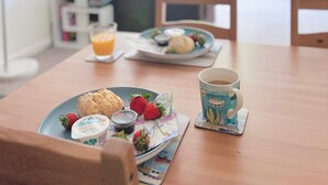 Una tavola imbandita per la colazione, con un piatto di cibo, una tazza e un bicchiere di succo d'arancia.