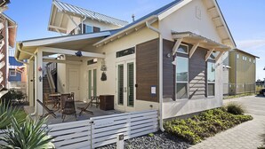 Una casa moderna con un porche cubierto, una escalera y un patio.