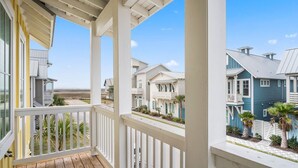 A wooden porch with a view of a beachfront community. - Resort Pools, Golf Cart Boardwalk to the Beach (Port Aransas)