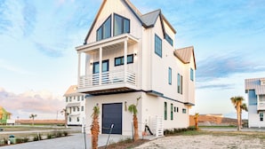 A two-story house with a balcony, large windows, and a garage.