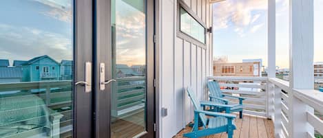 Relax on the balcony with two Adirondack chairs, taking in the view of the coastal area and surrounding landscape.