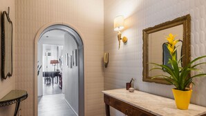 A hallway with a mirror, a lamp, and a potted plant.