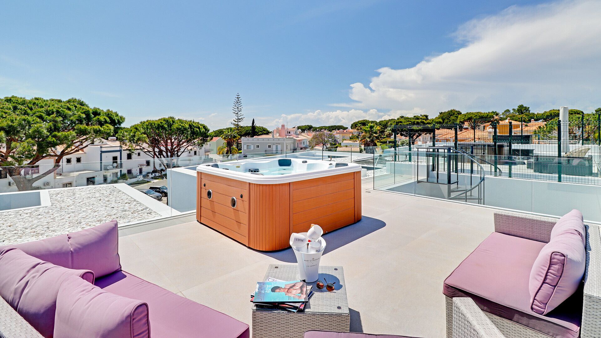 A rooftop terrace with a hot tub, seating area, and a clear view of the surrounding cityscape.