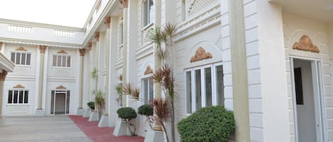 A building with a red carpeted walkway, white columns, and symmetrical architecture.