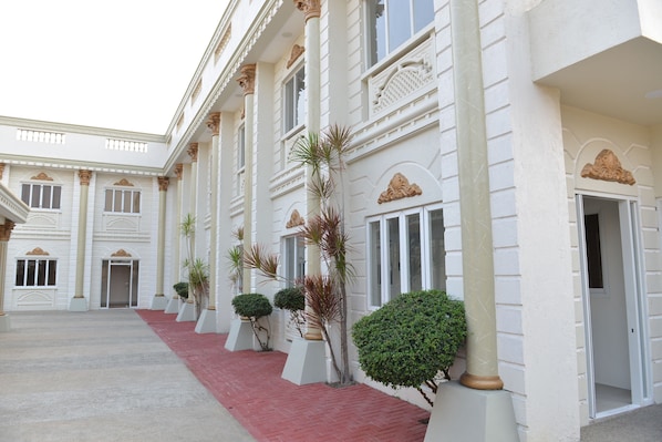 A building with a red carpeted walkway, white columns, and symmetrical architecture.
