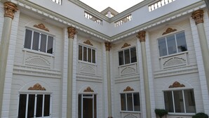 Un edificio blanco con múltiples ventanas y columnas decorativas.