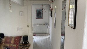 A narrow hallway with a radiator, a sofa, and a small table with a lamp. - Maison Sainte Foy La Grande (Pineuilh)