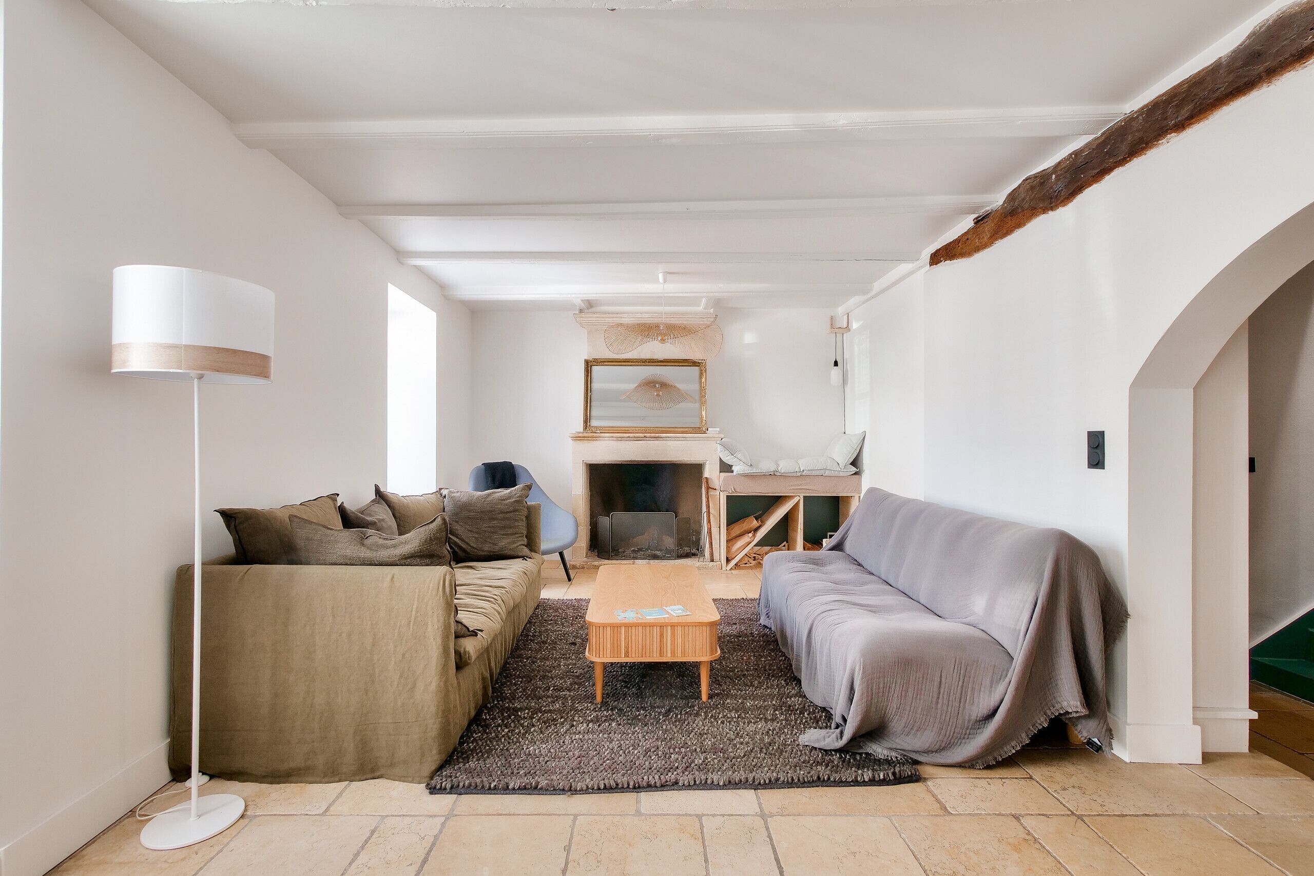A cozy living room with a sofa, a coffee table, and a floor lamp.