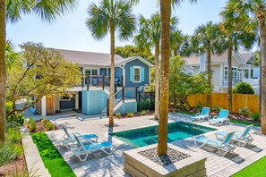 A backyard with a swimming pool, palm trees, and a house with blue siding. - 3 bedroom home,walk to beach,private pool,screened porch! (Isle of Palms)