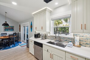 Enjoy meals in the kitchen with a stainless steel sink and dining area featuring a wooden table and chairs.