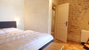 Een slaapkamer met een bed, een deur en een radiator.