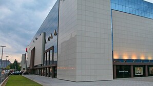 Un edificio moderno con una grande facciata vetrata e un ingresso ben visibile.
