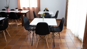 Un coin repas avec une table blanche, des chaises noires et des plantes en pot.