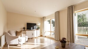 A spacious living room with a sofa, a coffee table, and a TV. - Charming Leopardstown Townhouse (Dublin)