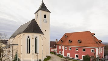 Eine Kirche mit einem Glockenturm und ein benachbartes Gebäude mit rotem Dach.