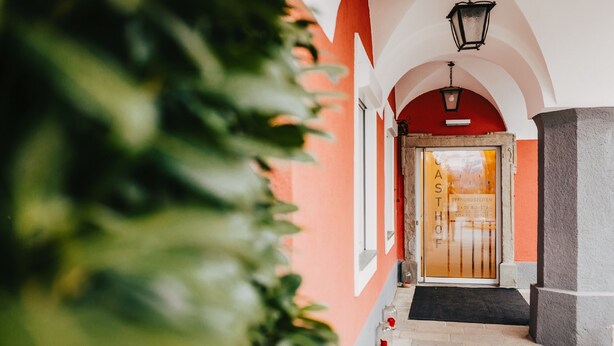 A hallway with a red wall, a door labeled "CAST," and a black doormat.