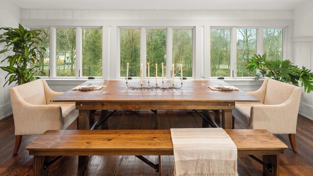 A dining room with a large wooden table, two chairs, a bench, and a candle holder. - 4BR Vermont Condo | Stowe Mountain & River Access (Stowe)