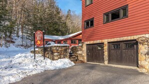 Un edificio rojo con paredes de piedra, un letrero que dice The Inn at Turner Mill, y un paisaje cubierto de nieve.