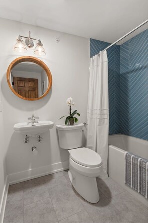 Bathtub, hair dryer, towels, shampoo