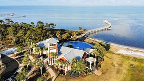 A coastal property with a swimming pool, a pier, and a road leading to the beach. - Bay Views with Pool and Gym Access (Port St. Joe)