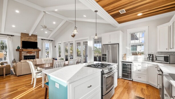 A spacious kitchen with white cabinetry, a large island, and a built-in oven. - Bay Views with Pool and Gym Access (Port St. Joe)