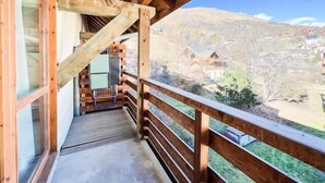 Een houten balkon met uitzicht op een bergdorp.