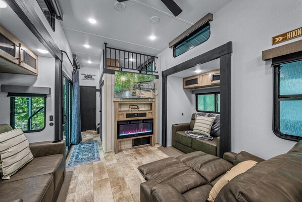 Smart TV, caminetto, libri, impianto stereo