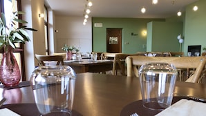 A dining area with a table set for two, including plates, cutlery, and clear drinking glasses. - AGRITURISMO FOREST B&B (Iseo)