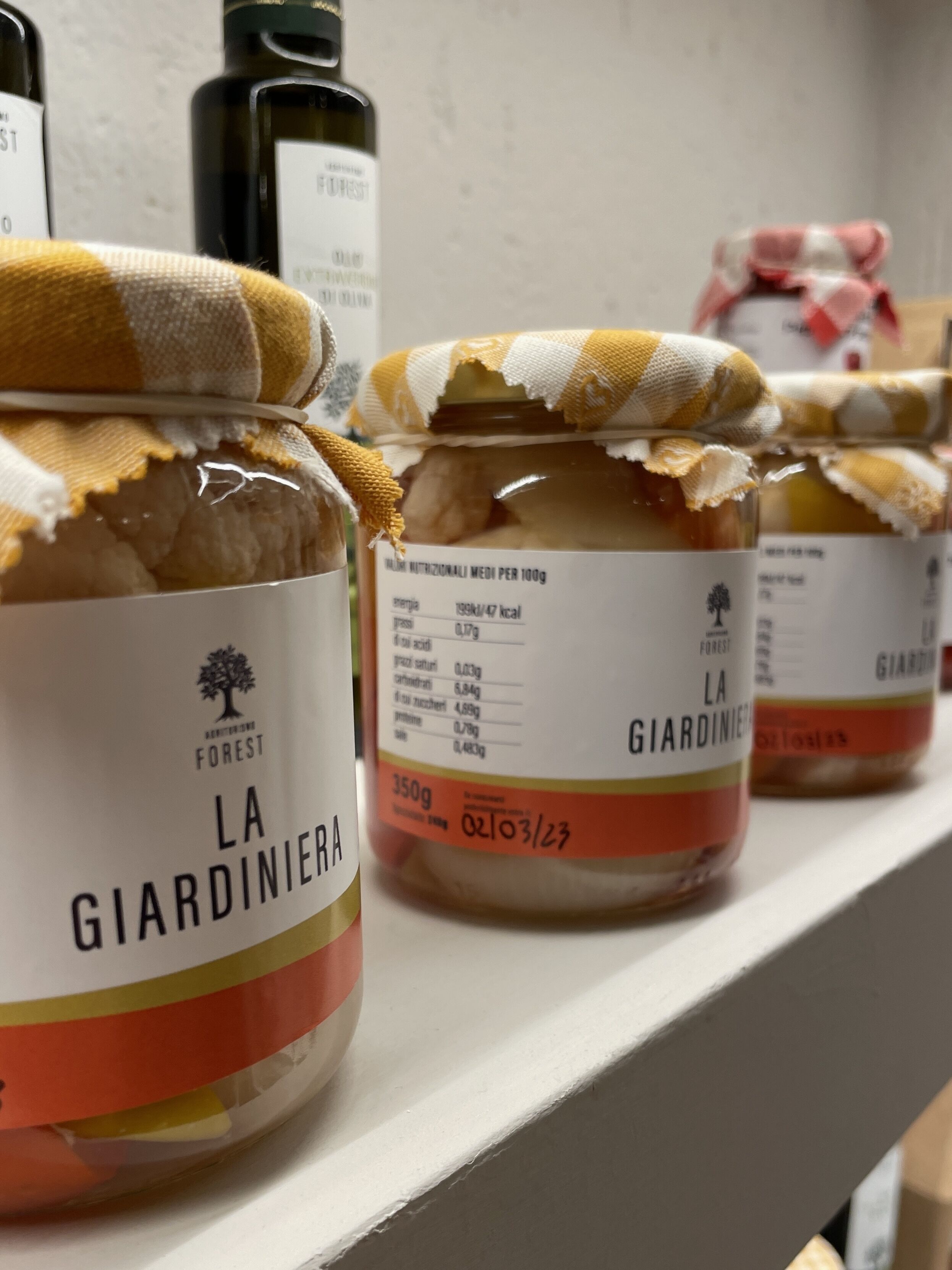 Jars of La Giardiniera on a shelf.