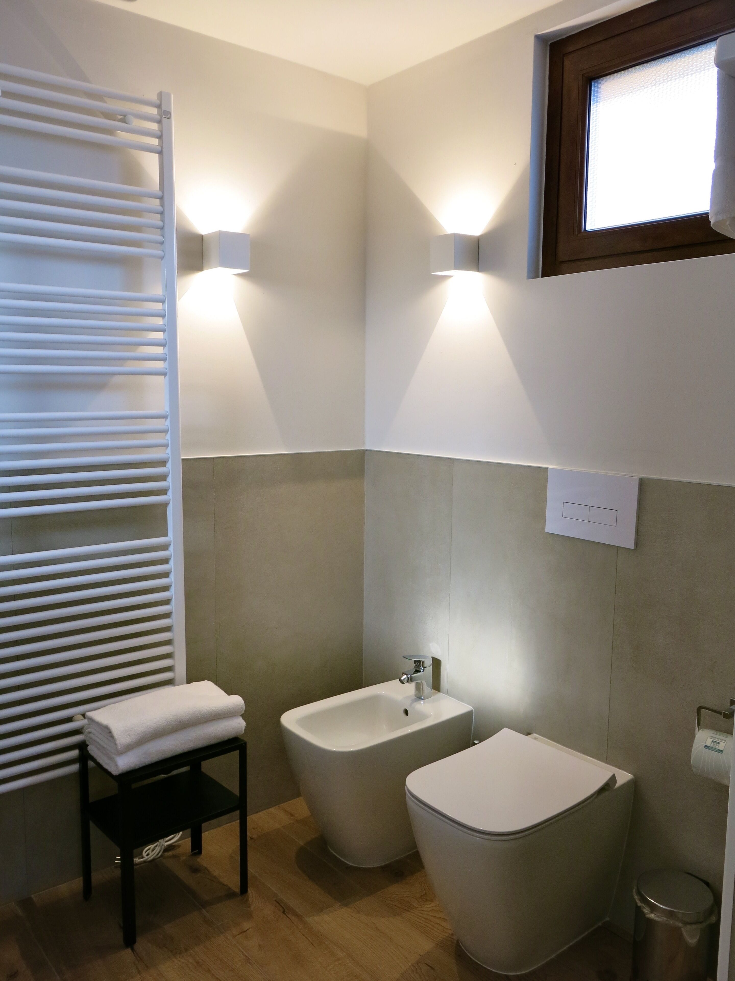 Un baño moderno con toallero, bidé e inodoro.