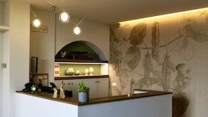 A modern kitchen with a central island, a microwave, and a refrigerator. - AGRITURISMO FOREST B&B (Iseo)