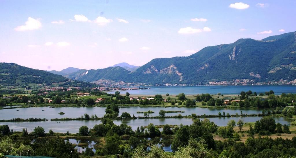 Ein Panoramablick auf eine Berglandschaft mit einem See und verstreuten Inseln.
