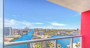 A high-rise building with a view of a marina and cityscape.