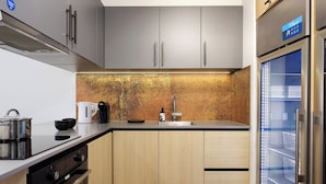 A modern kitchen with stainless steel appliances, a coffee maker, and a built-in refrigerator. - smartments Frankfurt City-Ost (Frankfurt)