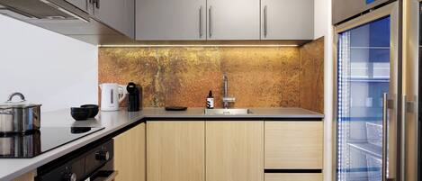 A modern kitchen with stainless steel appliances, a coffee maker, and a built-in refrigerator.