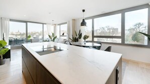 Una cocina moderna con una isla grande, ventanas amplias y un comedor con vistas.